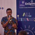 An early stage entrepreneur holding a microphone and pitching to an audience
